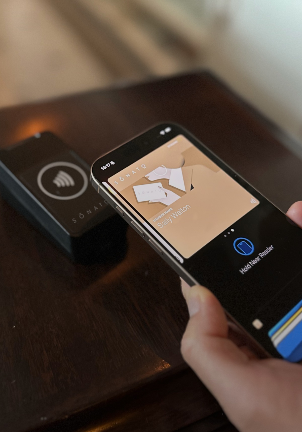 An iPhone showing the Sonato pass in Apple Wallet, tapping a Sonato-branded NFC reader
